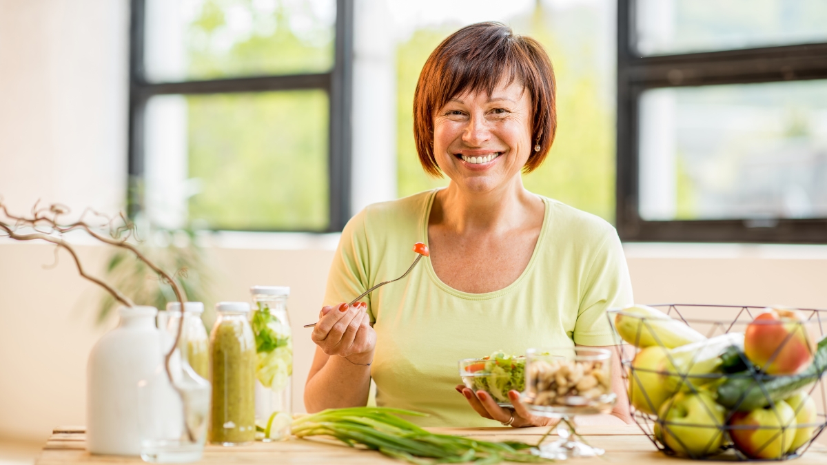 middle age woman eating healthy vegetables seated | 3 Ways to Reduce Inflammaging & Boost Health Over 50 | Creative Balance Health