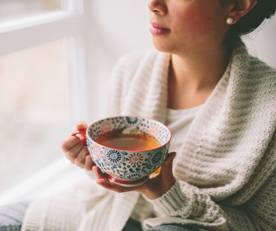 Woman drinking tea inside | Understanding Caffeine & Chronic Fatigue | Creative Balance Health